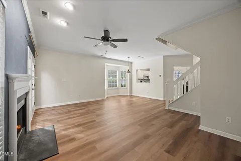 a view of an empty room with a fireplace and a window