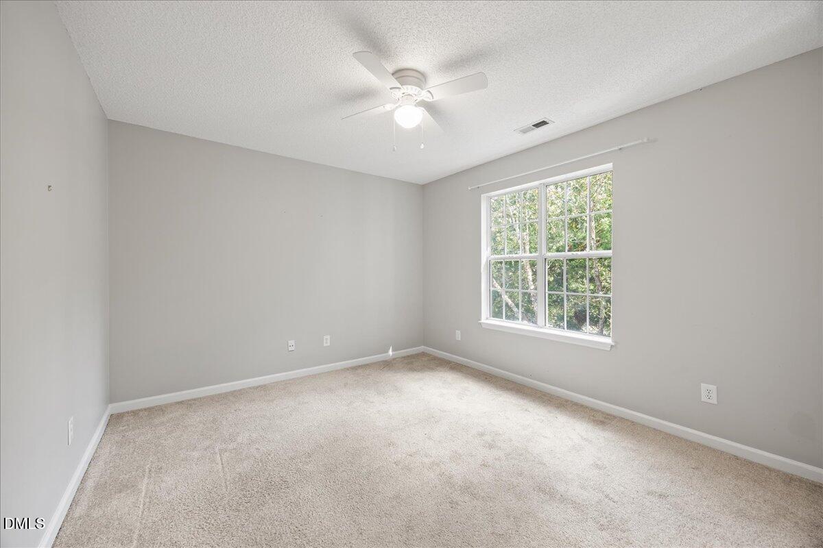 4329 Pine Springs Court Raleigh, NC 27613 - Photo 25 of 35 an empty room with windows and ceiling fan
