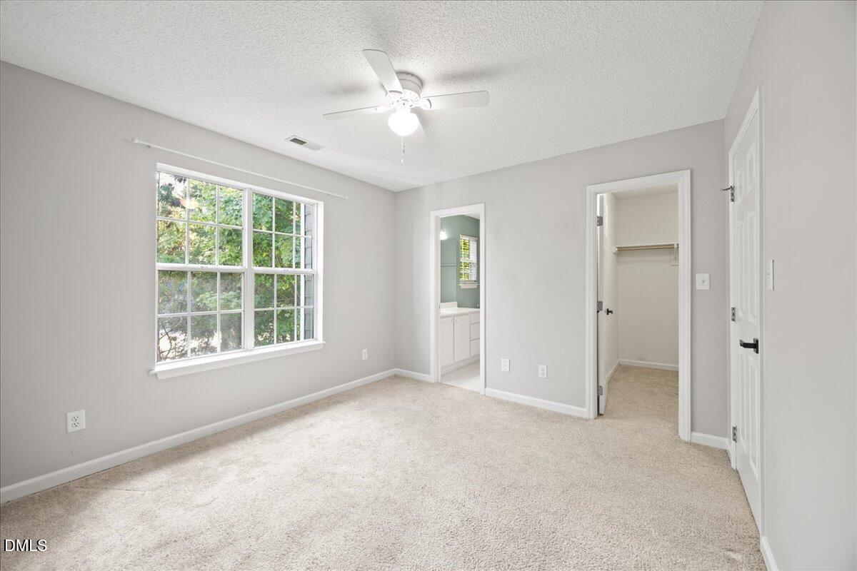4329 Pine Springs Court Raleigh, NC 27613 - Photo 26 of 35 an empty room with chandelier fan and windows