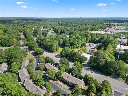an aerial view of residential house with outdoor space and trees all around