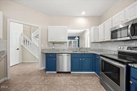 a kitchen with granite countertop a sink stove and microwave