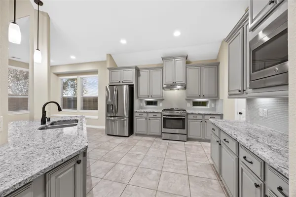a kitchen with stainless steel appliances granite countertop a sink stove and refrigerator