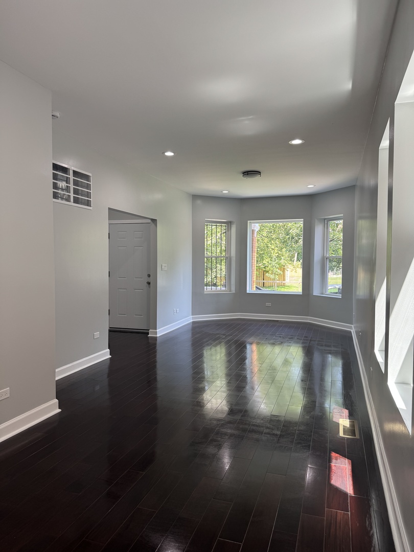 7204 South Union Avenue Chicago, IL 60621 - Photo 3 of 12 a view of empty room with wooden floor and fan