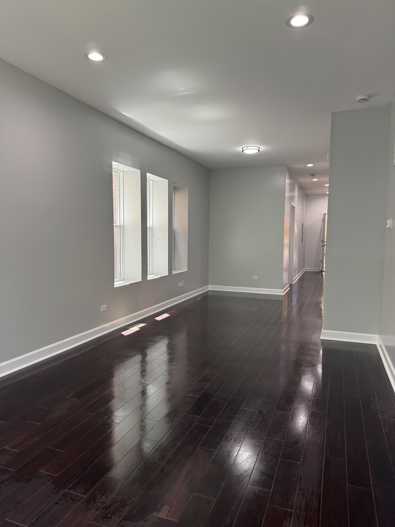 7204 South Union Avenue Chicago, IL 60621 - Photo 4 of 12 a view of an empty room with wooden floor and a window