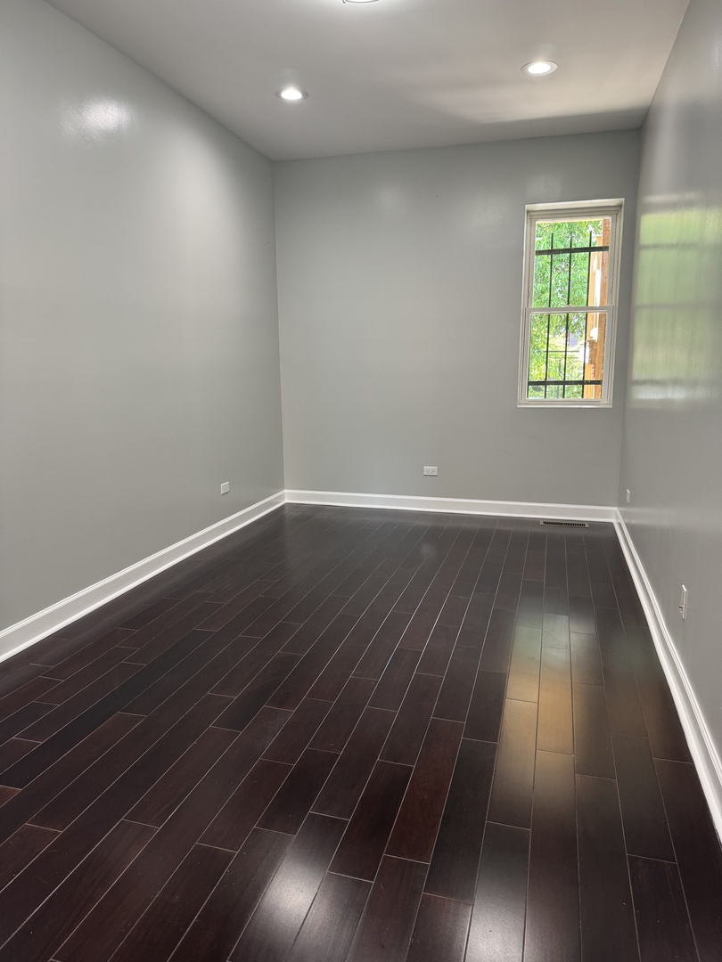 7204 South Union Avenue Chicago, IL 60621 - Photo 8 of 12 an empty room with wooden floor and windows