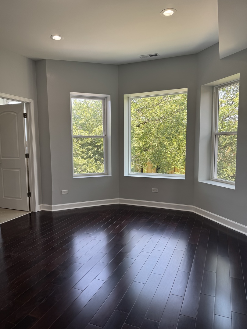 7204 South Union Avenue Chicago, IL 60621 - Photo 10 of 12 an empty room with wooden floor and windows