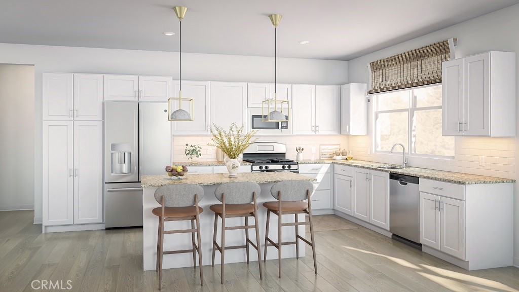 4102 East Elma Privado, Unit 101 Ontario, CA 91764 - Photo 4 of 5 a kitchen with stainless steel appliances kitchen island granite countertop a table chairs sink and cabinets