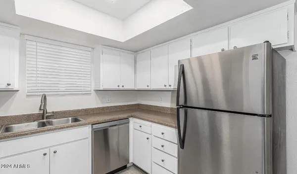 a kitchen with appliances a sink and cabinets