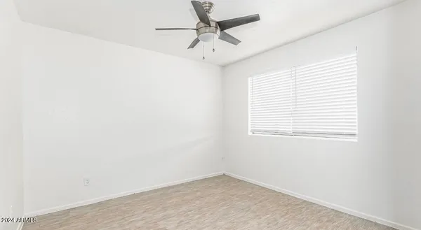an empty room with a window and a fan