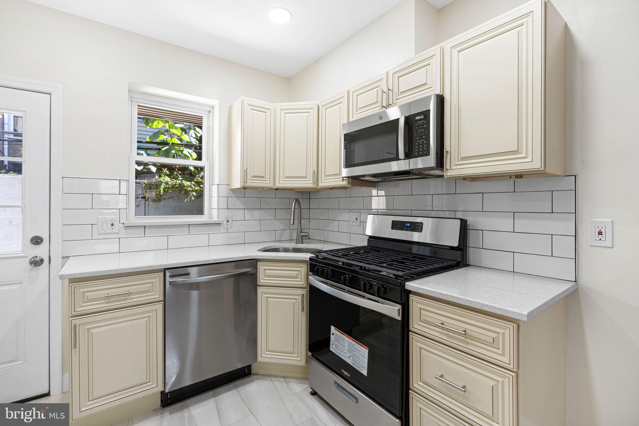 1535 South Mole Street Philadelphia, PA 19146 - Photo 6 of 28 a kitchen with stainless steel appliances granite countertop white cabinets a sink and a stove