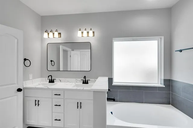a bathroom with a sink vanity and mirror