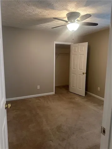 an empty room with chandelier fan
