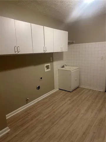 a view of a kitchen with white cabinets and wooden floor