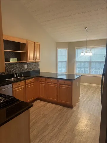 a kitchen with stainless steel appliances granite countertop a sink and a stove
