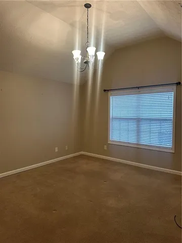 a view of a livingroom with a chandelier fan and a window