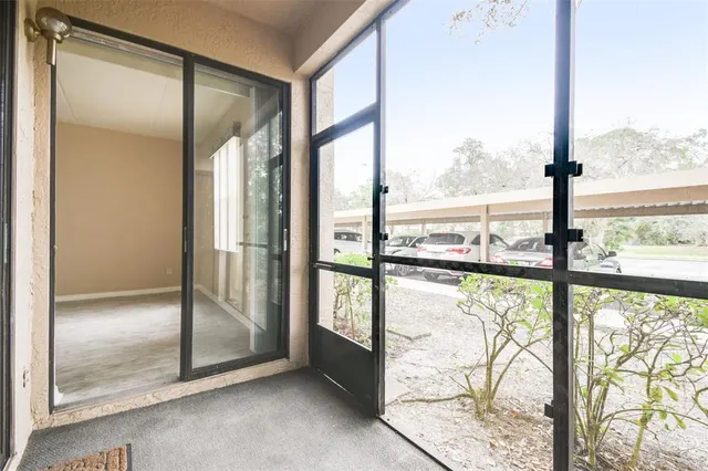 a view of an empty room with wooden floor and door