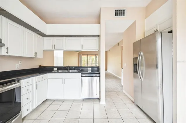 a kitchen with stainless steel appliances granite countertop a refrigerator and a stove