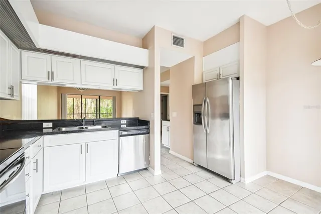 a kitchen with granite countertop a sink and a refrigerator