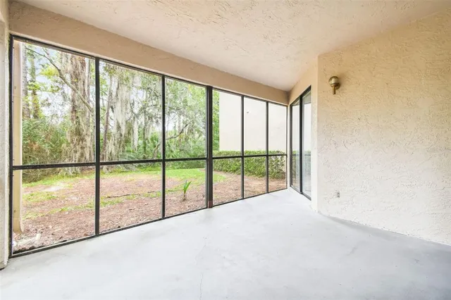 a view of an empty room with wooden floor and windows