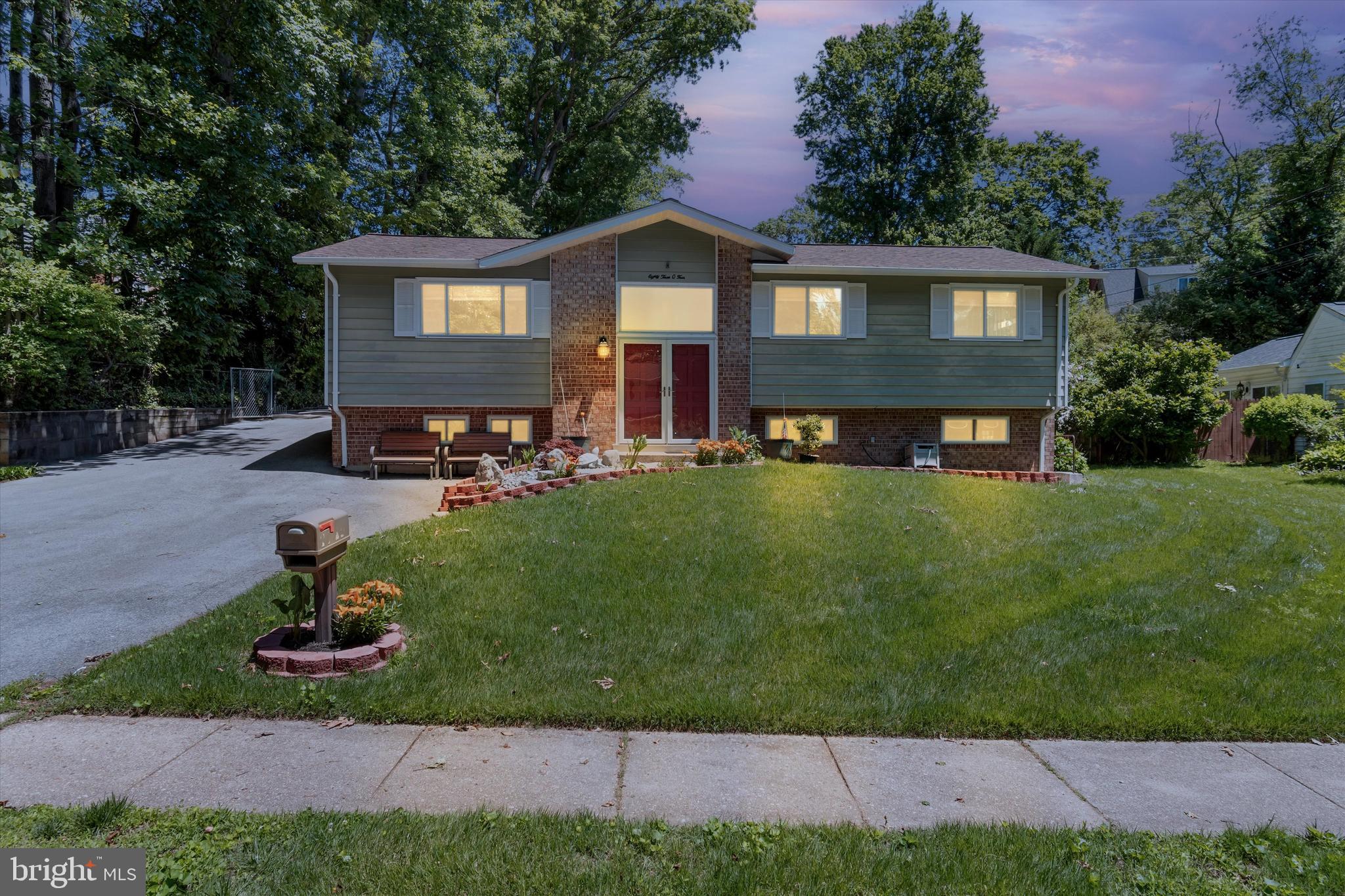8304 Harland Drive Springfield, VA 22152 - Photo 1 of 39 a front view of a house with a garden and trees