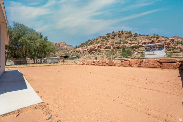 464 Jessop Avenue Hildale, UT 84784 - Photo 5 of 73 Expansive outdoor space featuring a large dirt area, a concrete patio, and a chain-link fence