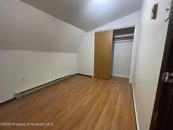 a view of empty room with wooden floor