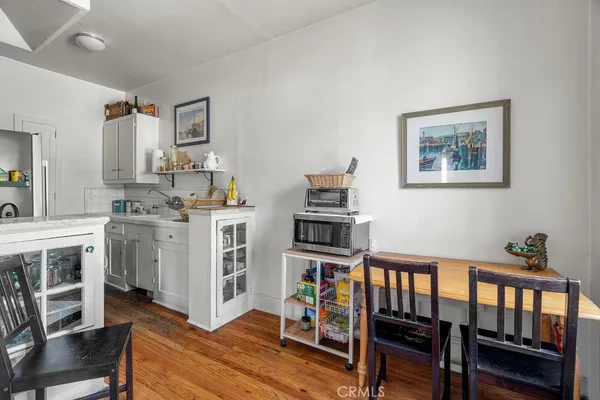a kitchen that has a lot of cabinets in it and wooden floors
