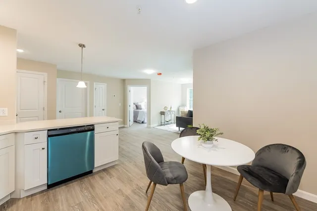 a kitchen with a dining table chairs and sink