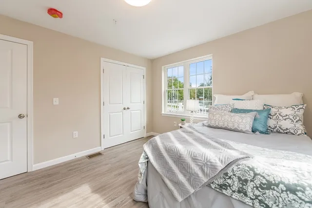 a bedroom with a large bed and wooden floor
