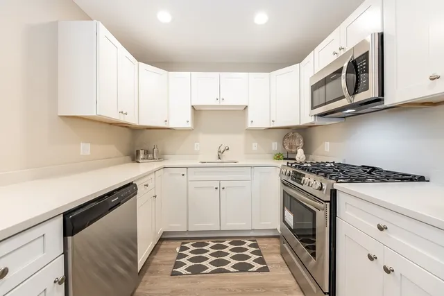 a kitchen with stainless steel appliances granite countertop a stove and a microwave