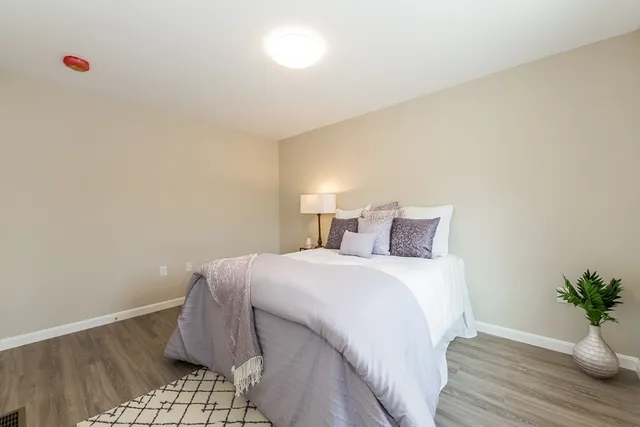 a bedroom with a bed and wooden floor