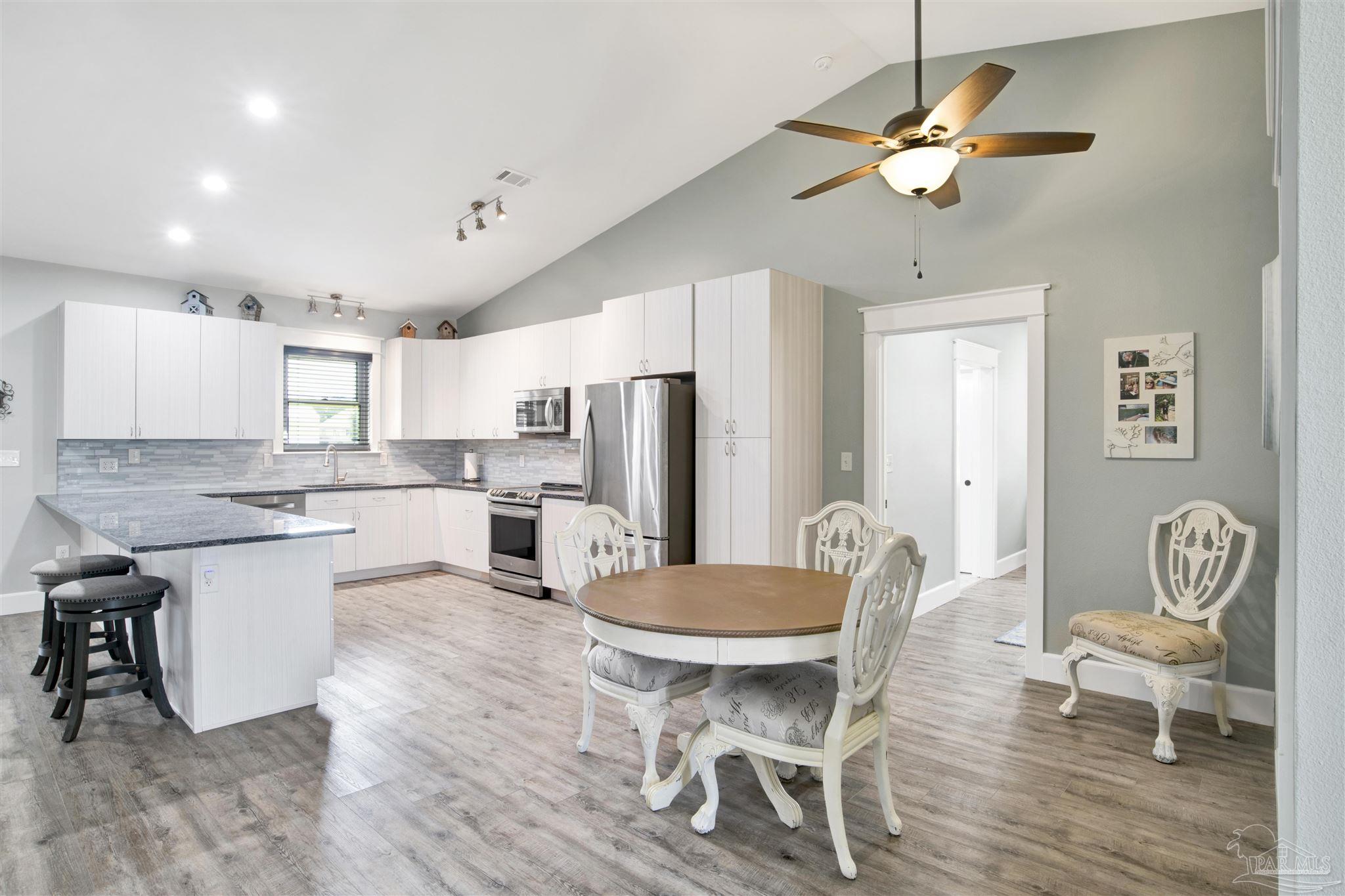 2549 Santa Rosa Drive Lillian, AL 36549 - Photo 14 of 53 a kitchen with a dining table chairs cabinets and stainless steel appliances