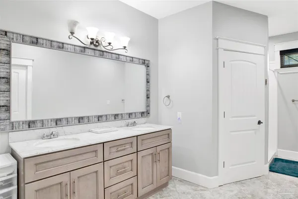 a bathroom with a double vanity sink a mirror and a shower