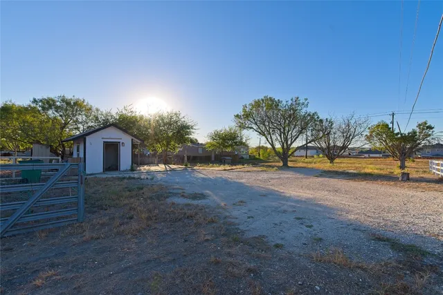 a view of a yard with wooden fence