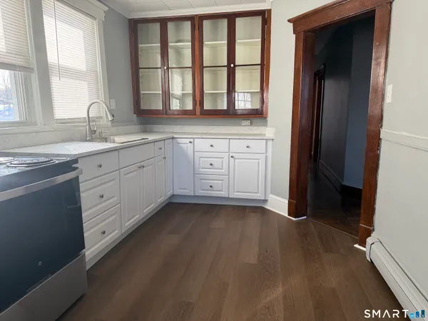 a kitchen with white cabinets and a window