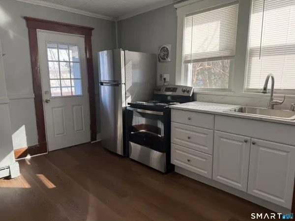 a kitchen with stainless steel appliances granite countertop a refrigerator sink and window