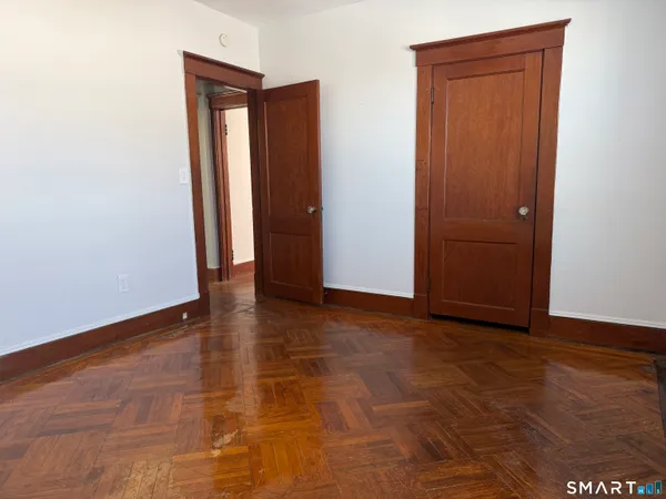 an empty room with wooden floor and closet