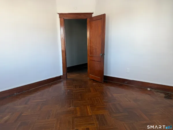 a view of an empty room with closet and a window
