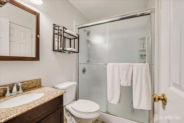 a bathroom with a granite countertop sink toilet and shower