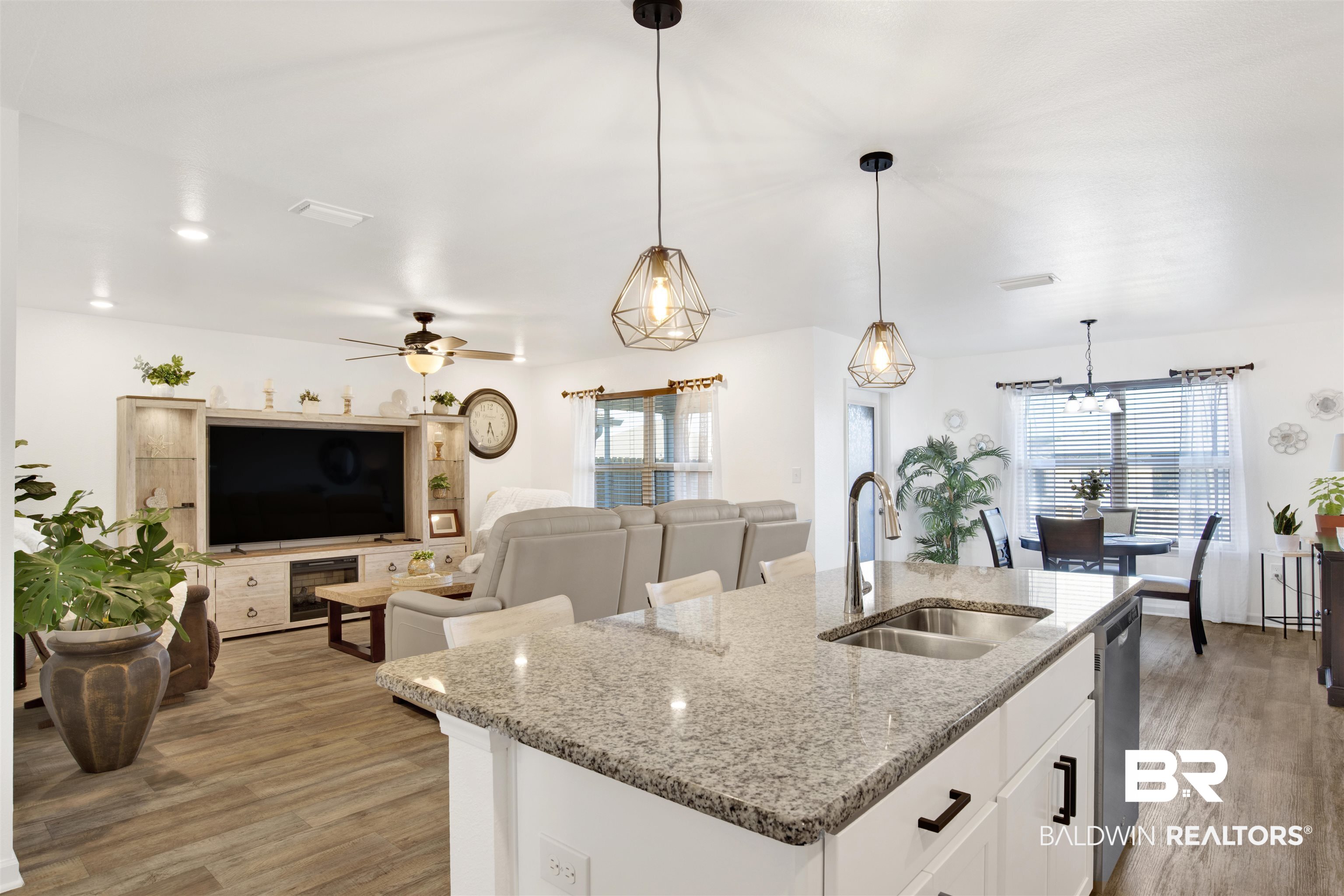 8102 Irwin Loop Daphne, AL 36526 - Photo 11 of 30 Kitchen featuring pendant lighting, a center island with sink, sink, light stone counters, and white cabinetry