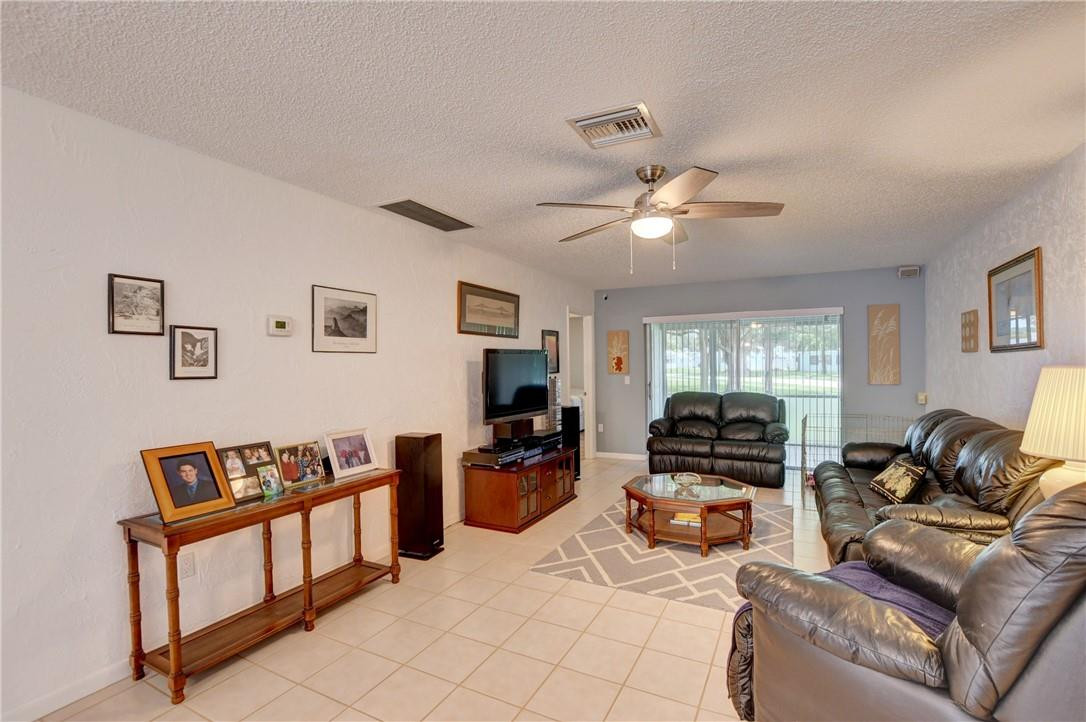 9285 Southwest 5th Street, Unit C Boca Raton, FL 33428 - Photo 17 of 31 a living room with furniture ceiling fan and a window