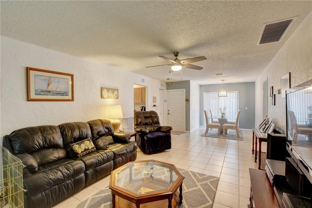 9285 Southwest 5th Street, Unit C Boca Raton, FL 33428 - Photo 18 of 31 a living room with furniture and a chandelier
