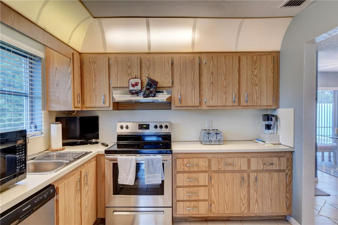 9285 Southwest 5th Street, Unit C Boca Raton, FL 33428 - Photo 23 of 31 a kitchen with stainless steel appliances granite countertop a sink and cabinets