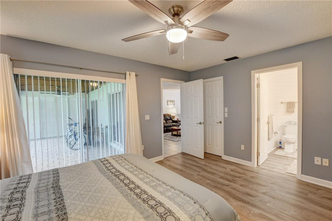 9285 Southwest 5th Street, Unit C Boca Raton, FL 33428 - Photo 27 of 31 a bedroom with a large bed and a chandelier