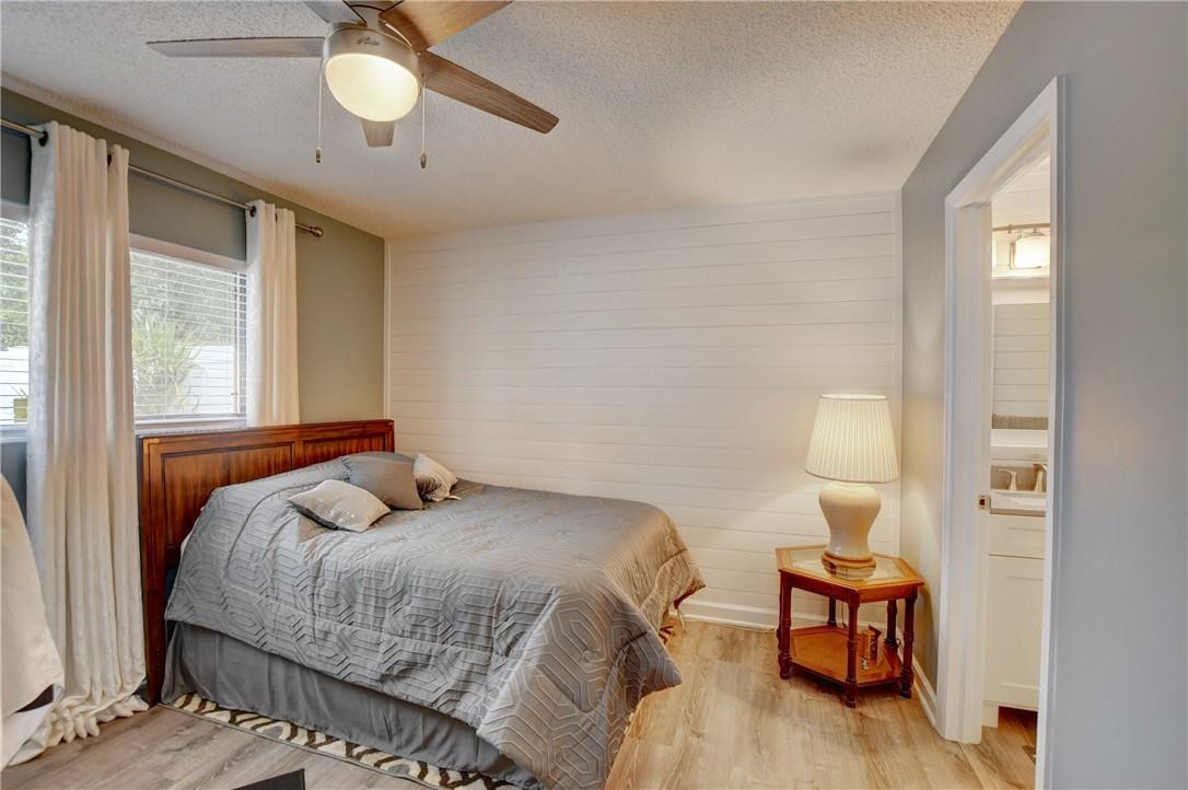 9285 Southwest 5th Street, Unit C Boca Raton, FL 33428 - Photo 29 of 31 a bedroom with a bed and wooden floor