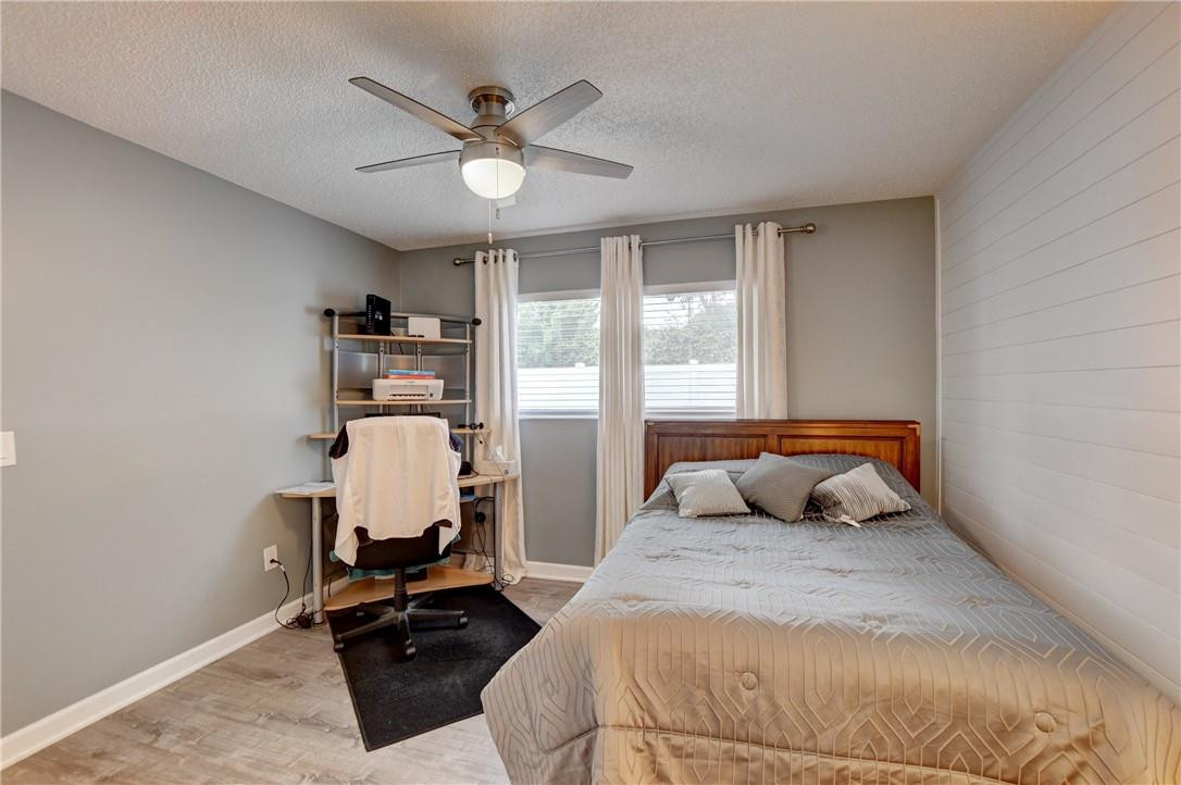 9285 Southwest 5th Street, Unit C Boca Raton, FL 33428 - Photo 30 of 31 a bedroom with a bed and a chandelier