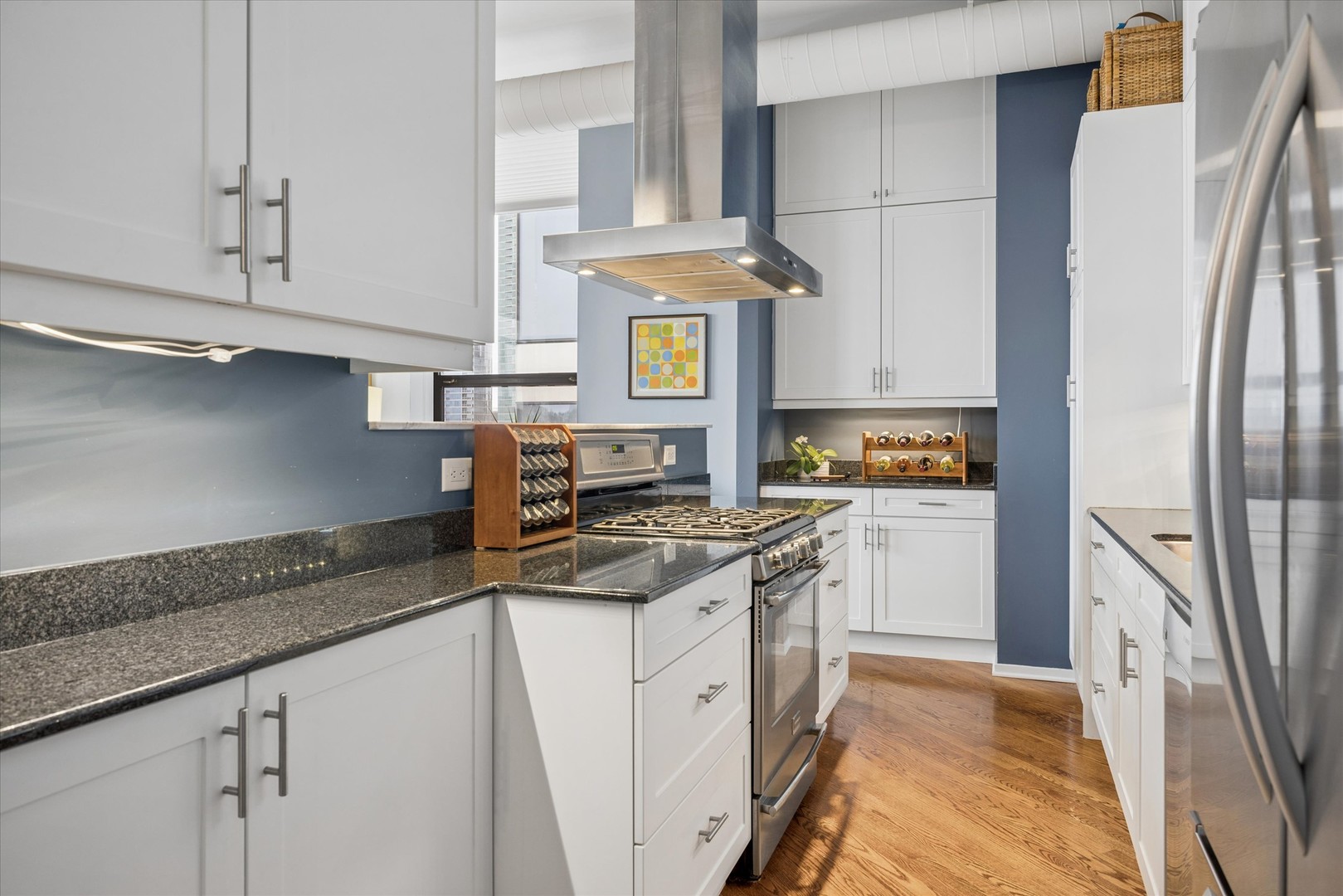910 South Michigan Avenue, Unit 501 Chicago, IL 60605 - Photo 8 of 21 a kitchen with stainless steel appliances granite countertop a refrigerator a stove and white cabinets with wooden floor