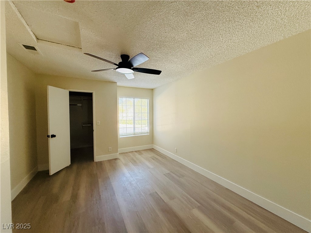 2200 South Fort Apache Road, Unit 2095 Las Vegas, NV 89117 - Photo 14 of 16 Unfurnished bedroom with a textured ceiling, wood finished floors, and a ceiling fan
