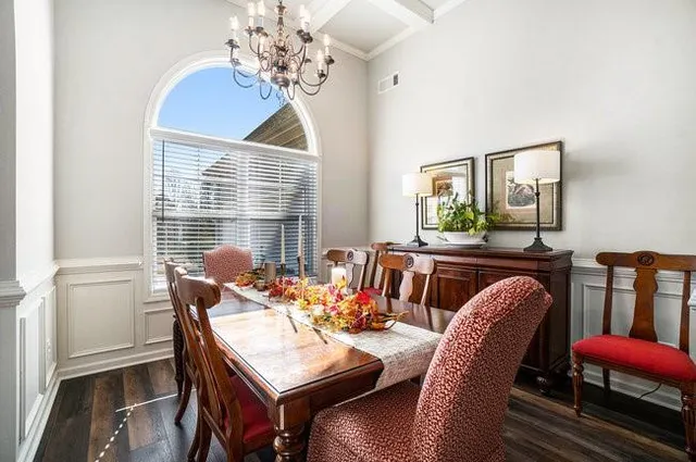 a living room with furniture chandelier and a window