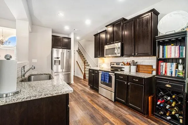 a kitchen with stainless steel appliances granite countertop a stove refrigerator and cabinets